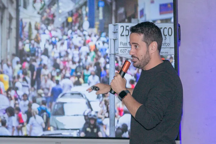 Alexandre Lemos apresentando com o microfone na mão