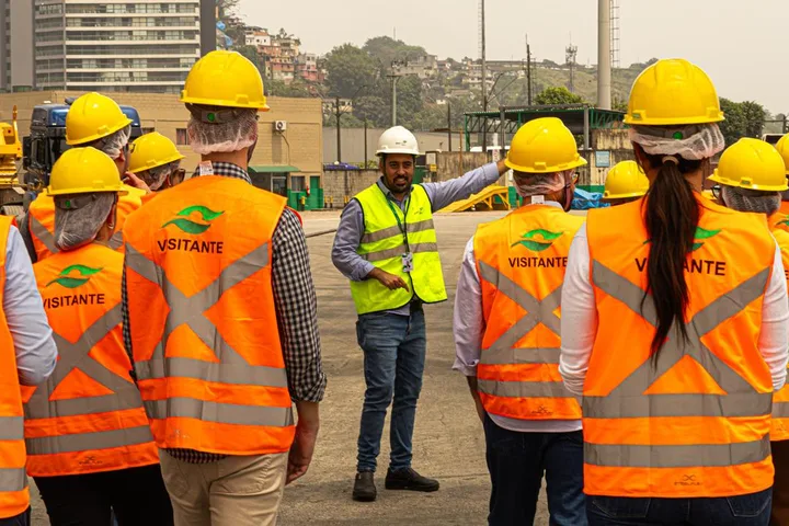 Equipe em visita a um terminal portuário, ouvindo as orientações