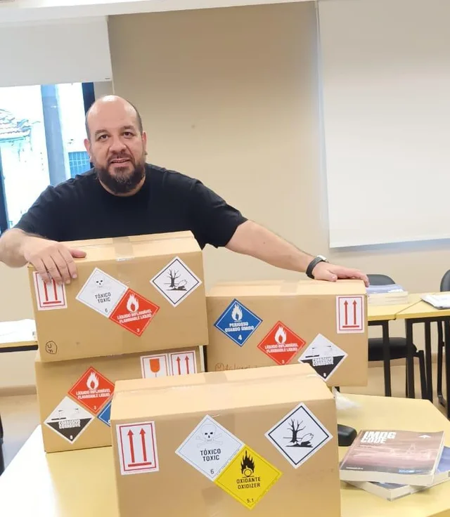 Ricardo Mafra com caixas de carga perigosa sinalizadas com etiquetas de risco
